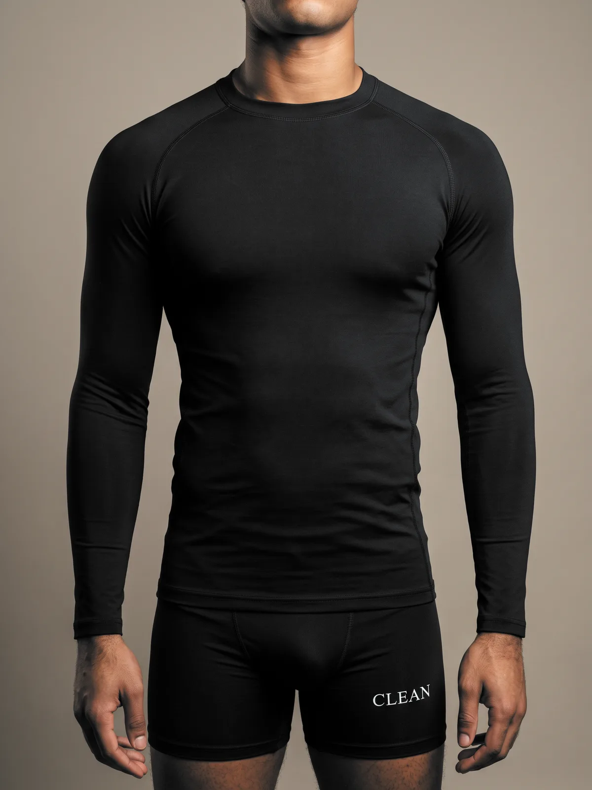 Model wearing the black long-sleeve rash guard with compression shorts, front view from the chin to the thigh.
